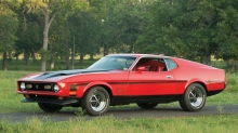 Красный Ford Mustang на дорожке в летнем лесу